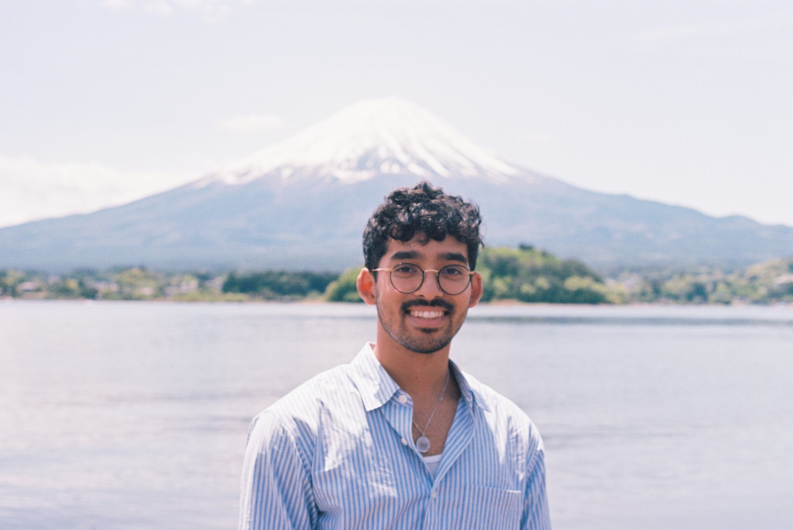 Raiyan Bhuiya smiling in front of Mt. Fuji and Lake Kawaguchiko